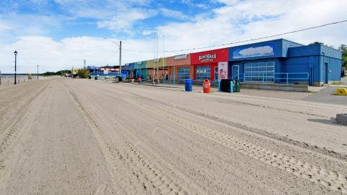 an empty road in front of a building at Main Beach River Retreat - Wasaga Beach 1 - Main Strip - 93 Mosley St in Wasaga Beach
