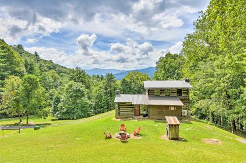 a log cabin in the middle of a field with chairs at Turkey Hollow Cabin with Stunning Open Views! in Clyde