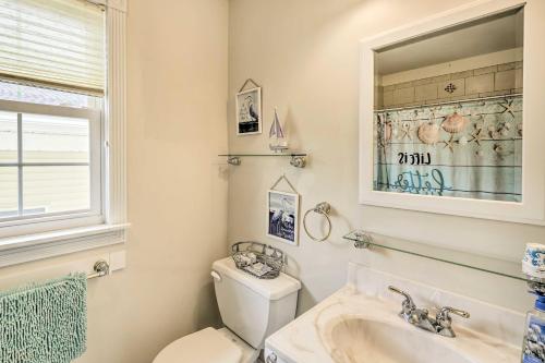 a bathroom with a toilet and a sink and a mirror at Ocean City Family Getaway about Qtr-Mi to Beach! in Ocean City