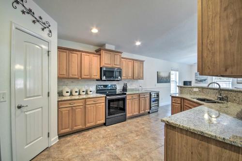 a kitchen with wooden cabinets and a stove top oven at Comfortable Pensacola Home with Private Pool! in Perdido Key