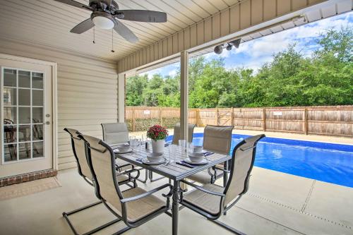 a dining room with a table and chairs and a pool at Comfortable Pensacola Home with Private Pool! in Perdido Key