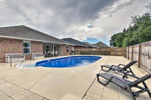 a swimming pool with two chairs next to a house at Comfortable Pensacola Home with Private Pool! in Perdido Key