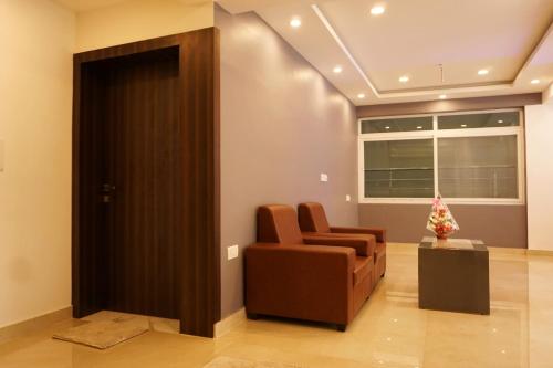 a waiting room with a chair and a door at Gateway Inn in Bengaluru