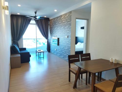 a dining room and living room with a table and chairs at ExcluSuites Malacca @ The Wave Residence in Melaka