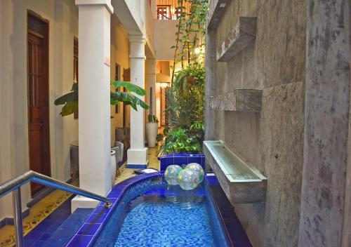 - une piscine au milieu d'un bâtiment dans l'établissement Casa Rosa - Alma Hotels, à Santa Marta