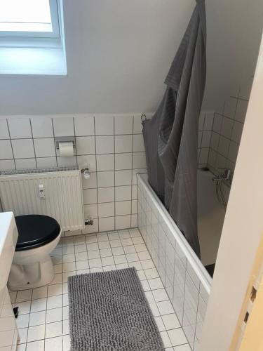 a small bathroom with a toilet and a shower at 25 qm Ferienwohnung Neuss Furth in Neuss