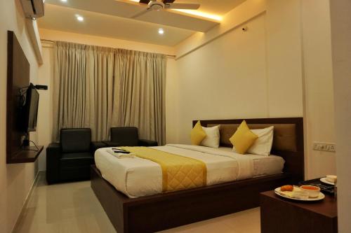 une chambre d'hôtel avec un lit et une chaise dans l'établissement Gateway Inn, à Bangalore