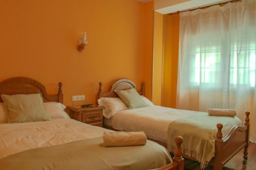 a bedroom with two beds and a window at Hostal Galicia in Monforte de Lemos