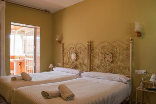 1 dormitorio con 2 camas y toallas. en Hostal Galicia, en Monforte de Lemos