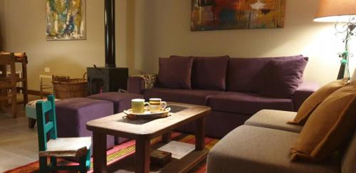 a living room with a purple couch and a table at La Casa de los Molles in Tilcara