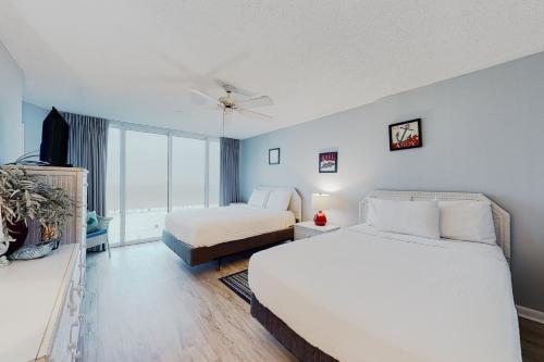 a hotel room with two beds and a television at Long Beach Resort #T2-304 in Panama City Beach