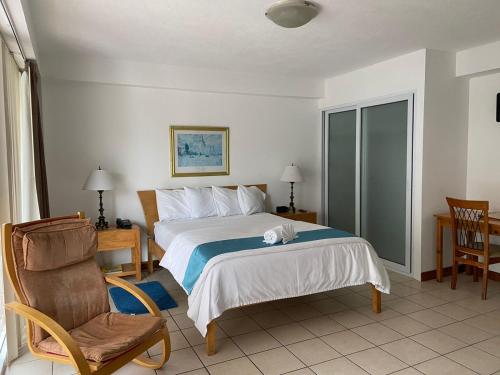 a hotel room with a bed and a chair at Apartamentos Reforma in Guatemala