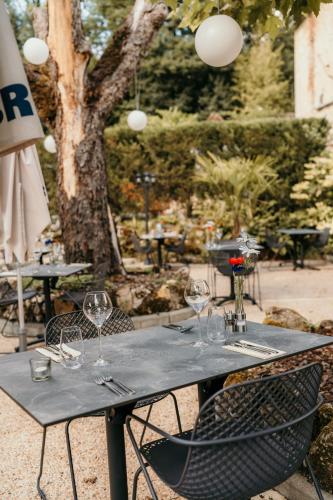 a black table with wine glasses on it at Hôtel Le Cro-Magnon in Les Eyzies-de-Tayac
