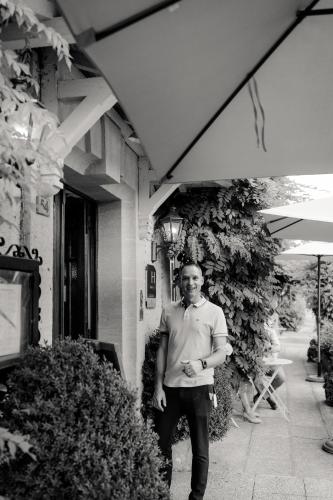 a man is standing outside of a building at Hôtel Le Cro-Magnon in Les Eyzies-de-Tayac