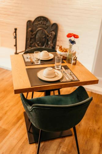 a wooden table with a green chair and a wooden tableablish at Hôtel Le Cro-Magnon in Les Eyzies-de-Tayac
