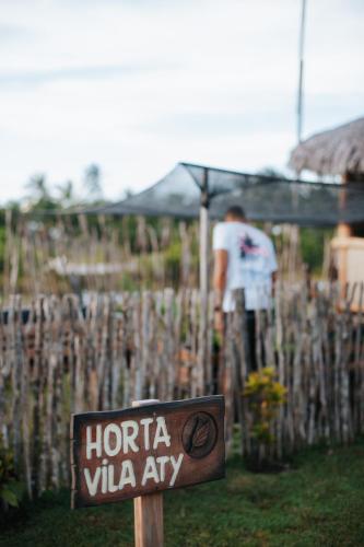 a sign in front of a vineyard with a man at VILA ATY LODGE in Atins