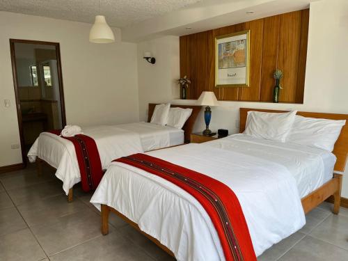 a hotel room with two beds with white sheets at Apartamentos Reforma in Guatemala