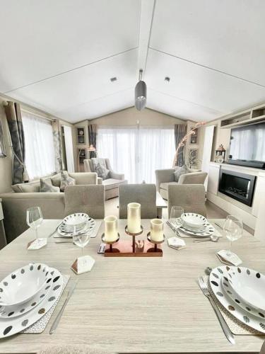a dining room with a table with plates and candles at 48 Pony Meadow - White Cross Bay in Windermere