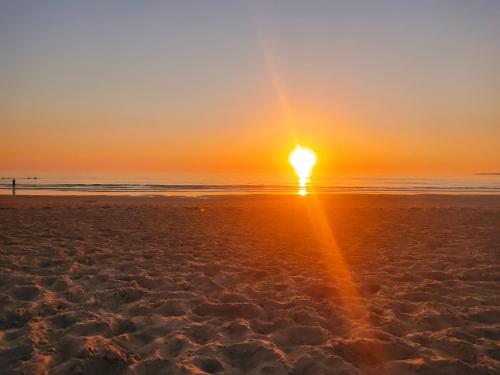 a sunset on a beach with the sun going down at Casa do Lucio in Rianjo