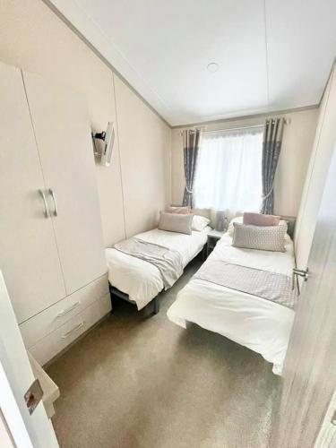 a room with three beds and a window at 48 Pony Meadow - White Cross Bay in Windermere