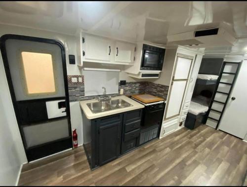 a small kitchen with a sink and a stove at Wildwood Camper De Sleeps 6-7, in Dover