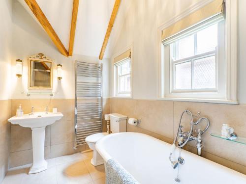 ein Badezimmer mit einer Badewanne, einem Waschbecken und einem WC in der Unterkunft Pinley Hill House in Shrewley