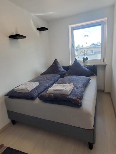 a bed with pillows on it in a room with a window at Luxus Apartment über den Dächern vom Allgäu in Sonthofen
