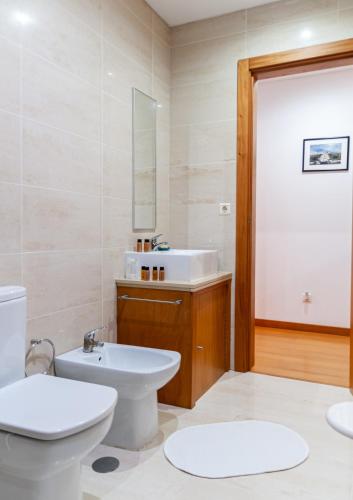 a bathroom with a white toilet and a sink at Sailorman and Friends in Ponta Delgada