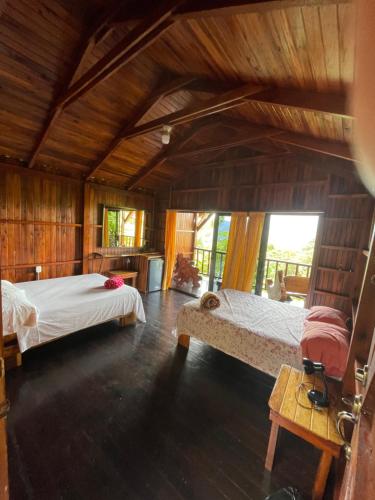 two beds in a room with wooden walls at Casa Torre Eco- Lodge in Fortuna