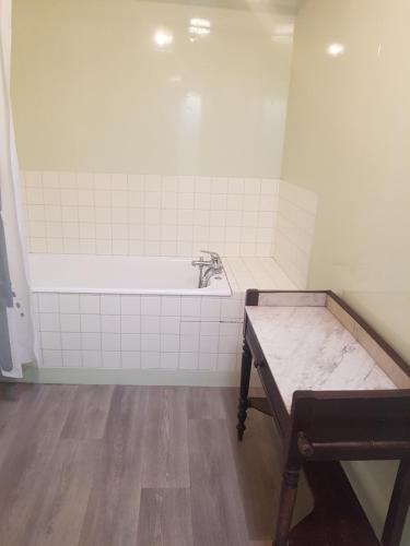 a bathroom with a bath tub and a wooden table at Le garage in Étretat