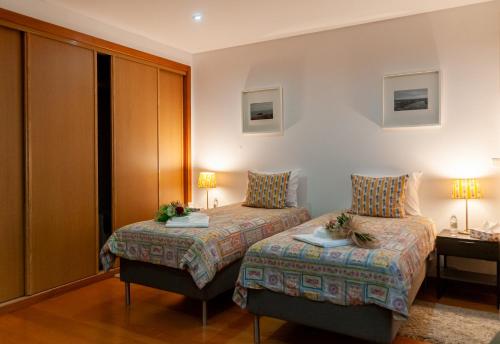 a hotel room with two beds and a desk at Sailorman and Friends in Ponta Delgada