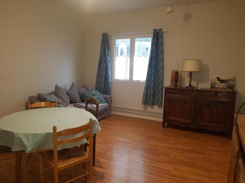 - un salon avec une table, un canapé et une fenêtre dans l'établissement Le garage, à Étretat