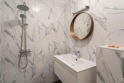 a white bathroom with a sink and a mirror at Designed Apartment in Central Sofia in Sofia