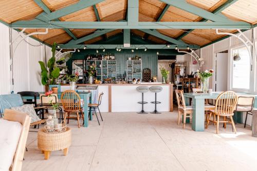 eine Terrasse mit Tischen und Stühlen sowie eine Bar in der Unterkunft Rijk aan Zee Ecolodges in Wijk aan Zee