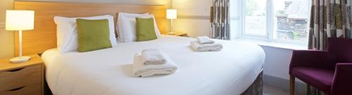 a hotel room with a large bed with towels on it at The Derwentwater Hotel in Keswick
