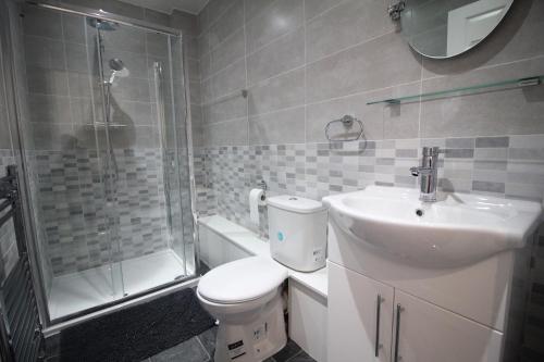 e bagno con servizi igienici, lavandino e doccia. di Tower View House - 4 Bedroom - Newly Refurbished - 2 Mins walk to Beach a Blackpool