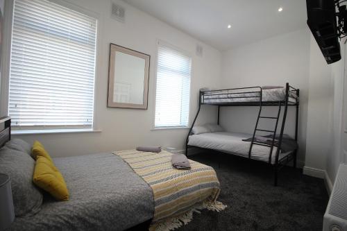a bedroom with two bunk beds and a ladder at Tower View House - 4 Bedroom - Newly Refurbished - 2 Mins walk to Beach in Blackpool