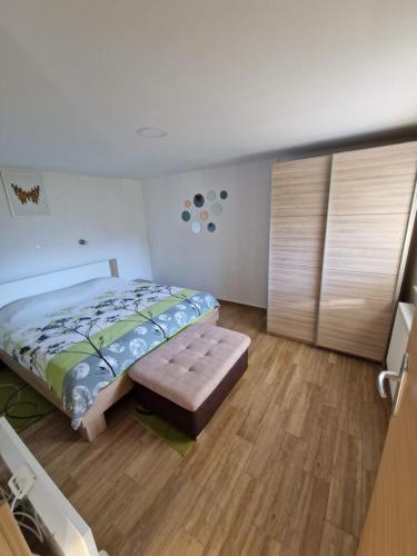 a bedroom with a bed and a bench in it at Apartma Vidovič in Rateče