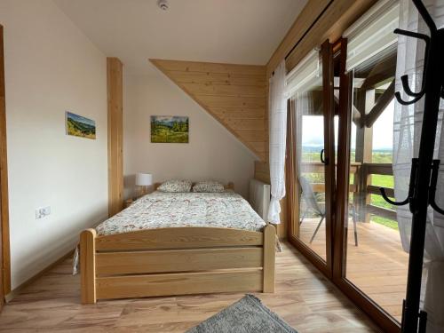 1 dormitorio con cama y ventana grande en Kolejowy Smolnik, en Smolnik