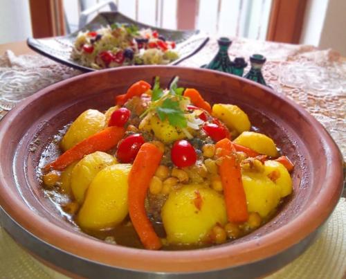 a bowl of food with carrots and potatoes on a table at Erg Chegaga Camp Excursions in Mhamid