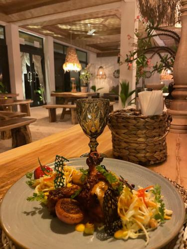 a plate of food on a table with a wine glass at Samura Panorama Guest House in Thulusdhoo