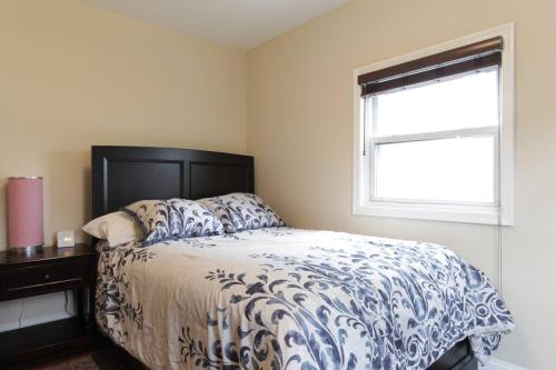 a bedroom with a bed with a blue and white comforter and a window at 2 bd 1 bth near DC! 7081 in Arlington