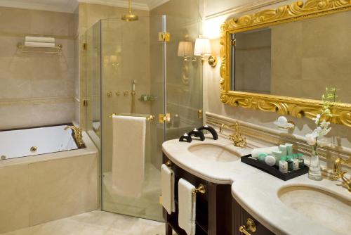 a bathroom with a sink and a shower and a mirror at Warwick Doha in Doha