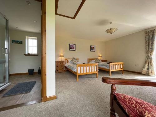 uma sala de estar com uma cama e um sofá em River Cottage em Forsinain