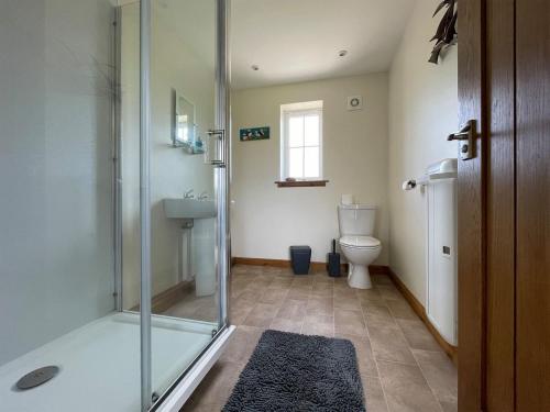 uma casa de banho com um chuveiro e um WC. em River Cottage em Forsinain