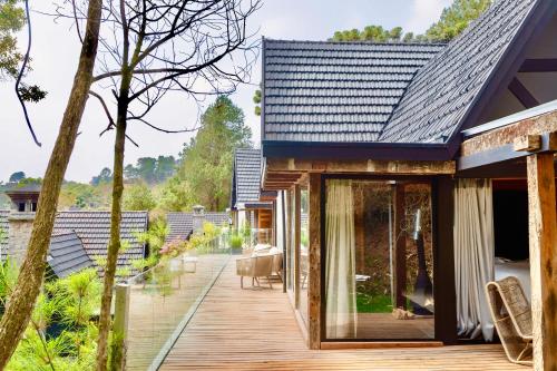 a house with a wooden deck and glass doors at Ort Hotel in Campos do Jordão