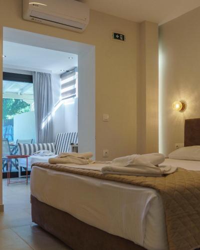 a bedroom with two beds and a living room at Zinozis Beach Apartments in Vourvourou