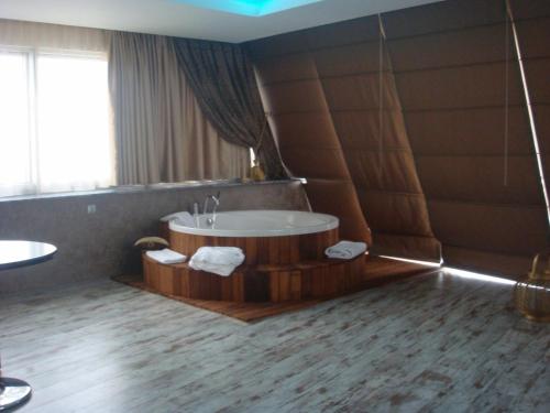 a bathroom with a tub and a sink in it at Golden Palas Hotel in Cerkezkoy