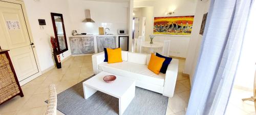 a living room with a white couch and yellow pillows at Branco Suites - Rooms & Holiday Apartments in Santa Maria