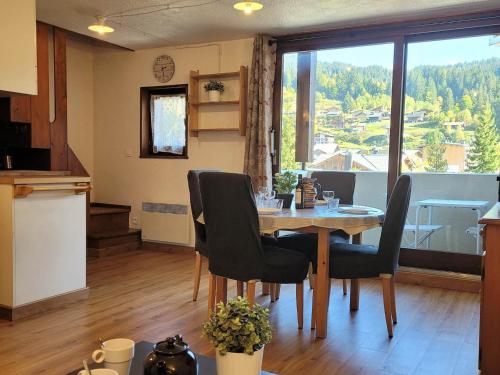 une cuisine et une salle à manger avec une table et des chaises dans l'établissement Duplex 3 pièces aux Gets, proche pistes avec parking et wifi - FR-1-598-23, aux Gets